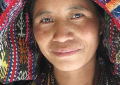 Woman from Xejuyú, Concepción with rainbow reflecting on her face and tzute.